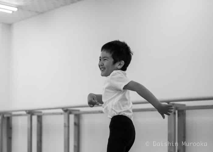 A boy is practicing ballet with lots of joys